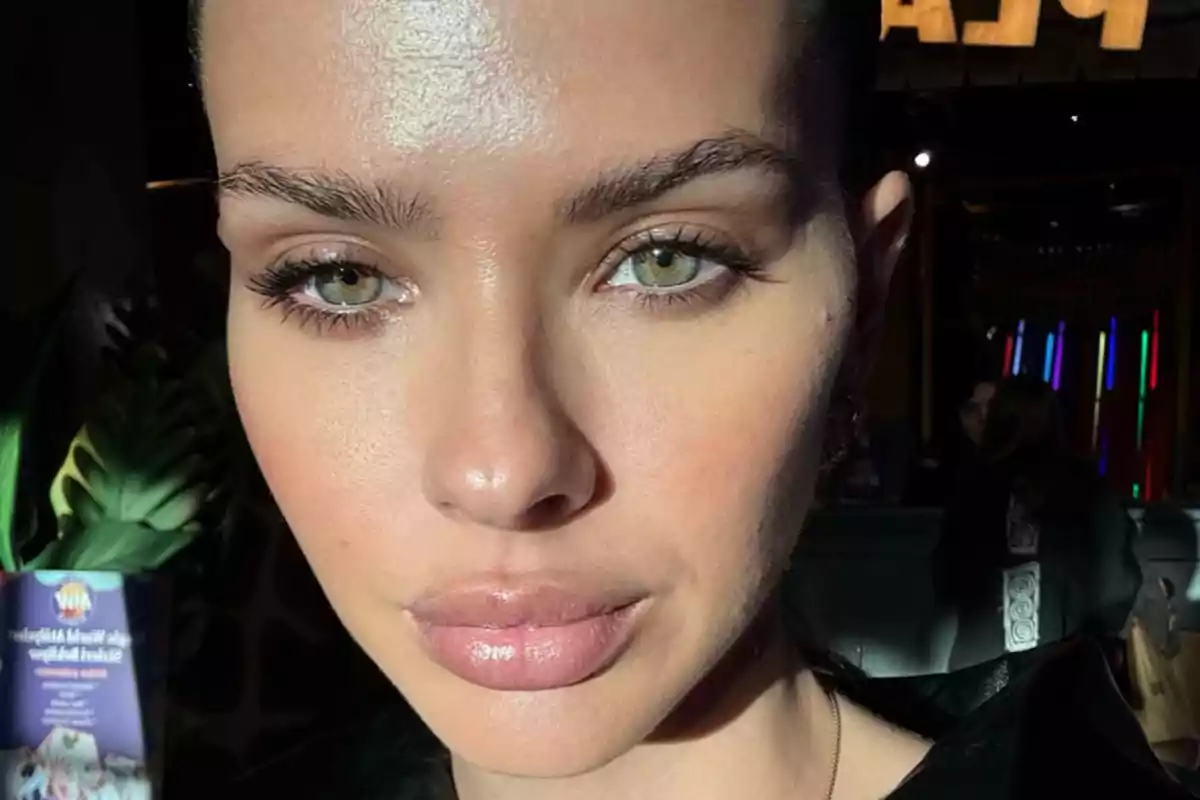 Close-up of a woman with green eyes and full lips illuminated by sunlight