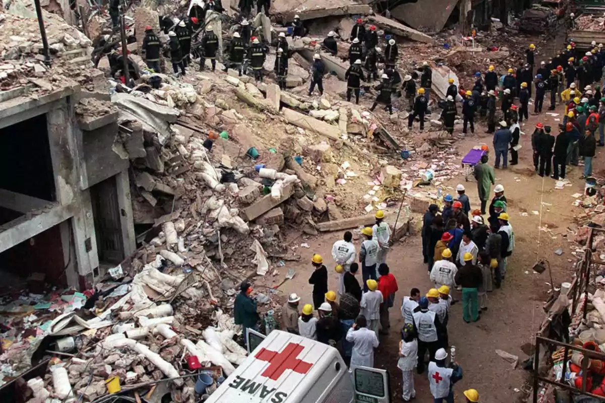 Rescuers and volunteers work among the rubble of a collapsed building while an emergency ambulance is parked nearby. Rescuers and volunteers work among the rubble of a collapsed building while an emergency ambulance is parked nearby.