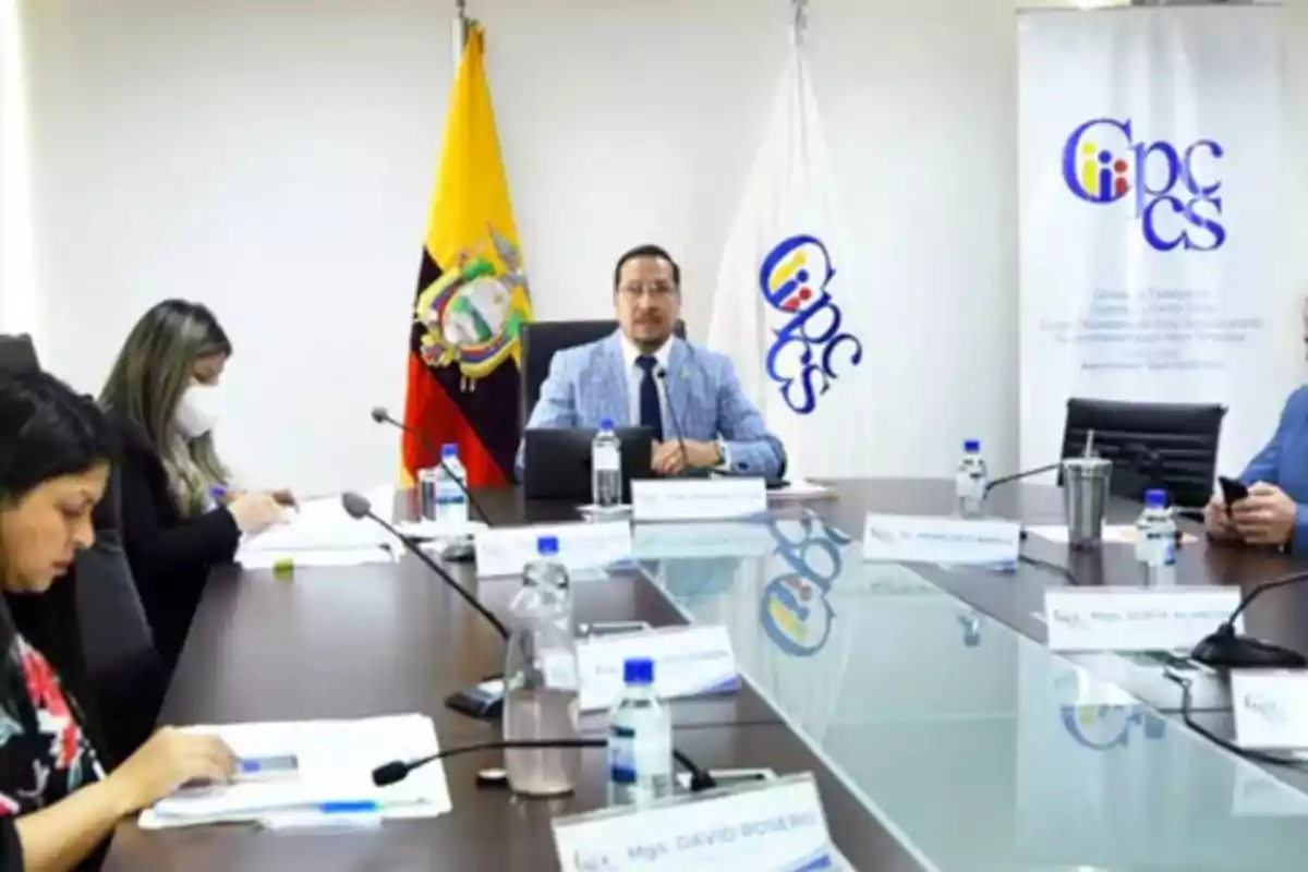 Meeting of several people in a conference room with flags and institutional logos in the background Meeting of several people in a conference room with flags and institutional logos in the background