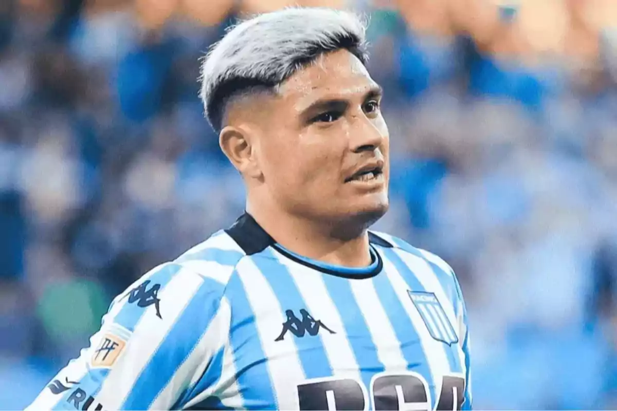 Soccer player with bleached blonde hair wearing the Racing Club jersey during a match