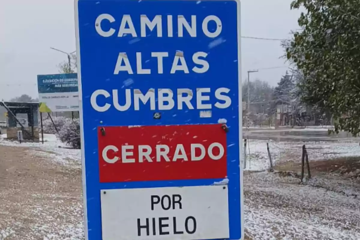 Blue sign in the snow indicating that the Altas Cumbres road is closed due to ice. Blue sign in the snow indicating that the Altas Cumbres road is closed due to ice.