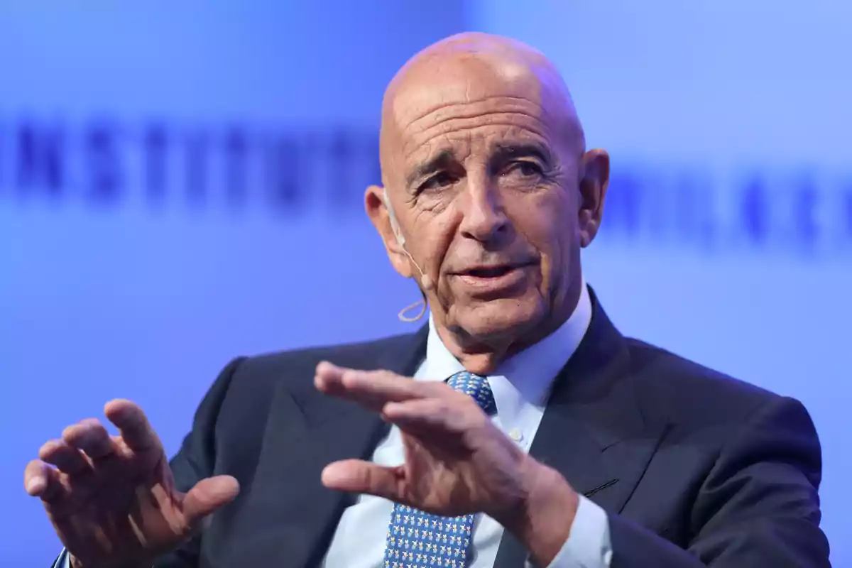 Bald man in a blue suit speaking with a headset microphone at a professional event Bald man in a blue suit speaking with a headset microphone at a professional event
