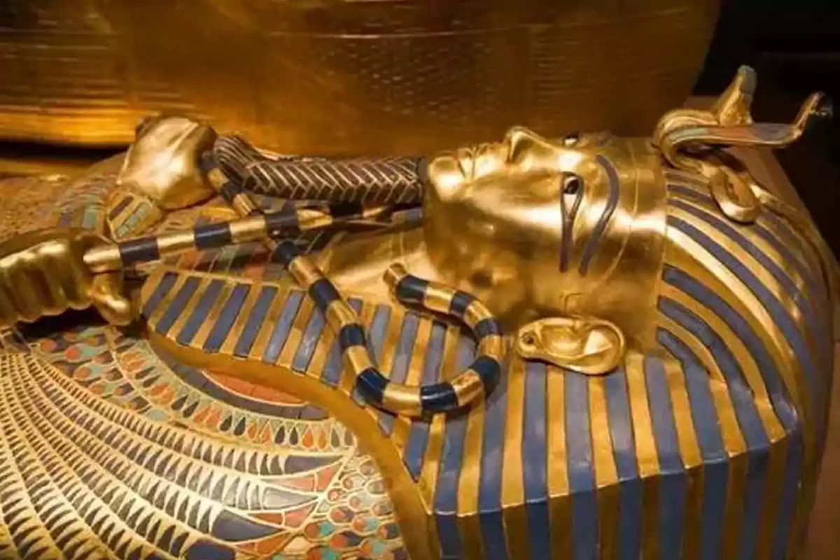 Sarcófago dorado del antiguo Egipto decorado con detalles en azul y negro