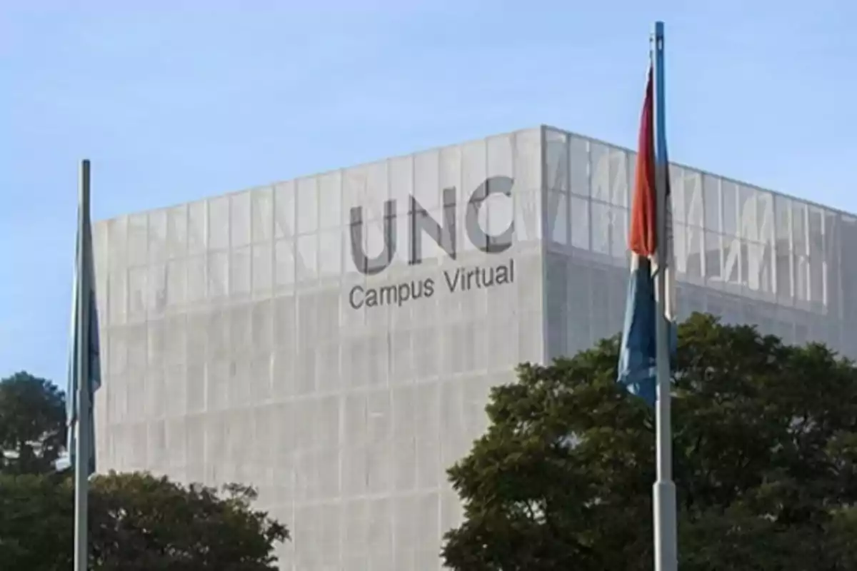 Edificio moderno de la UNC Campus Virtual con banderas y árboles en primer plano