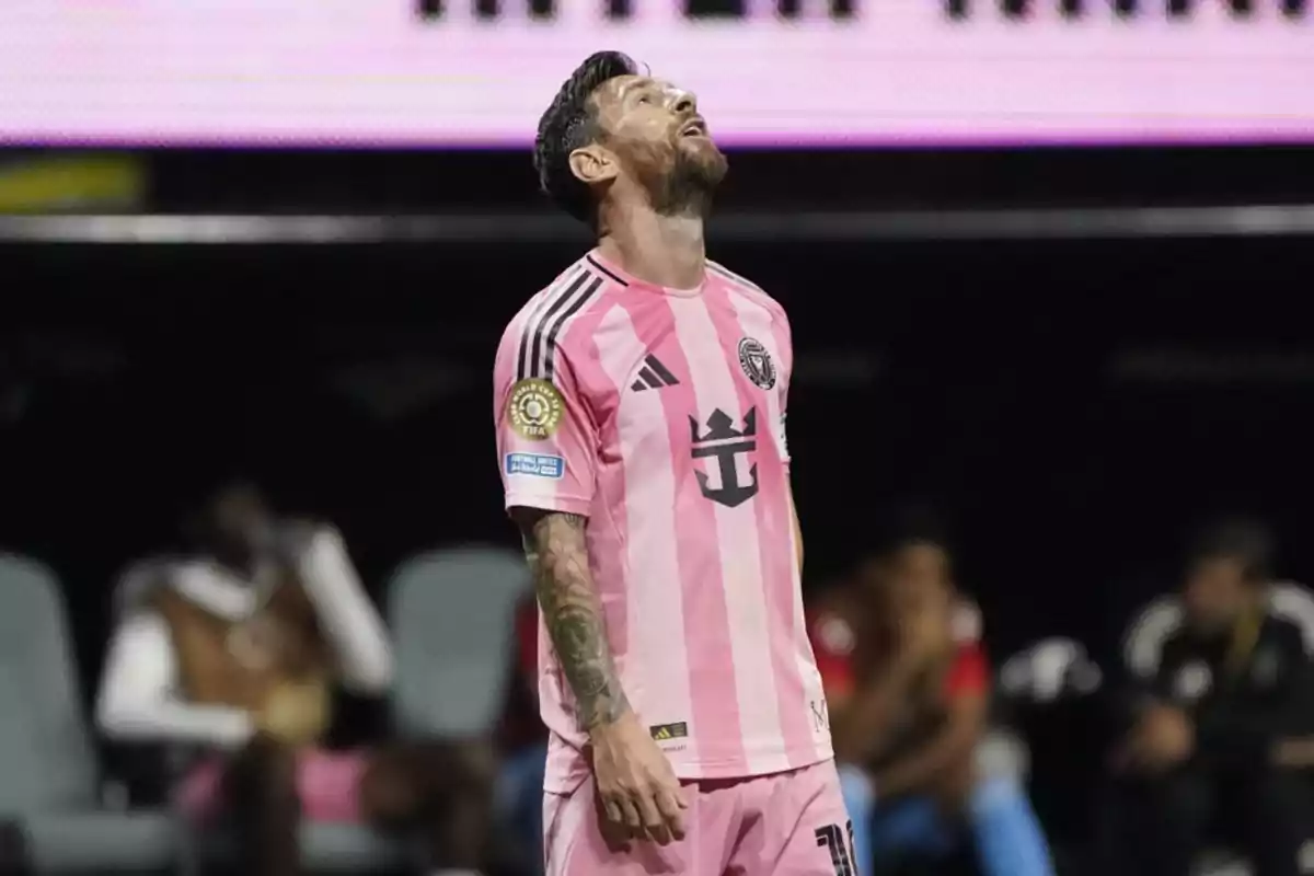 Futbolista con uniforme rosa mirando hacia arriba en el campo durante un partido Futbolista con uniforme rosa mirando hacia arriba en el campo durante un partido