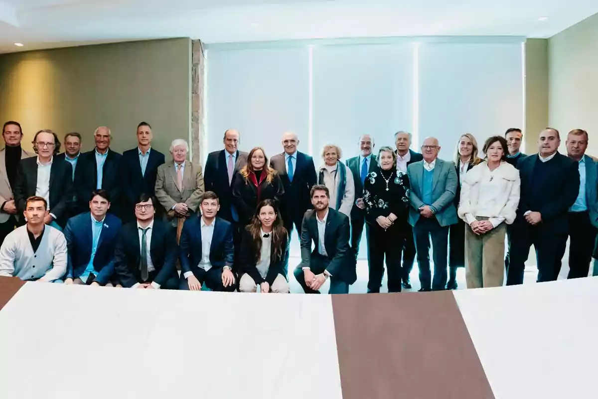 Un grupo de personas posando para una foto formal en un salón iluminado