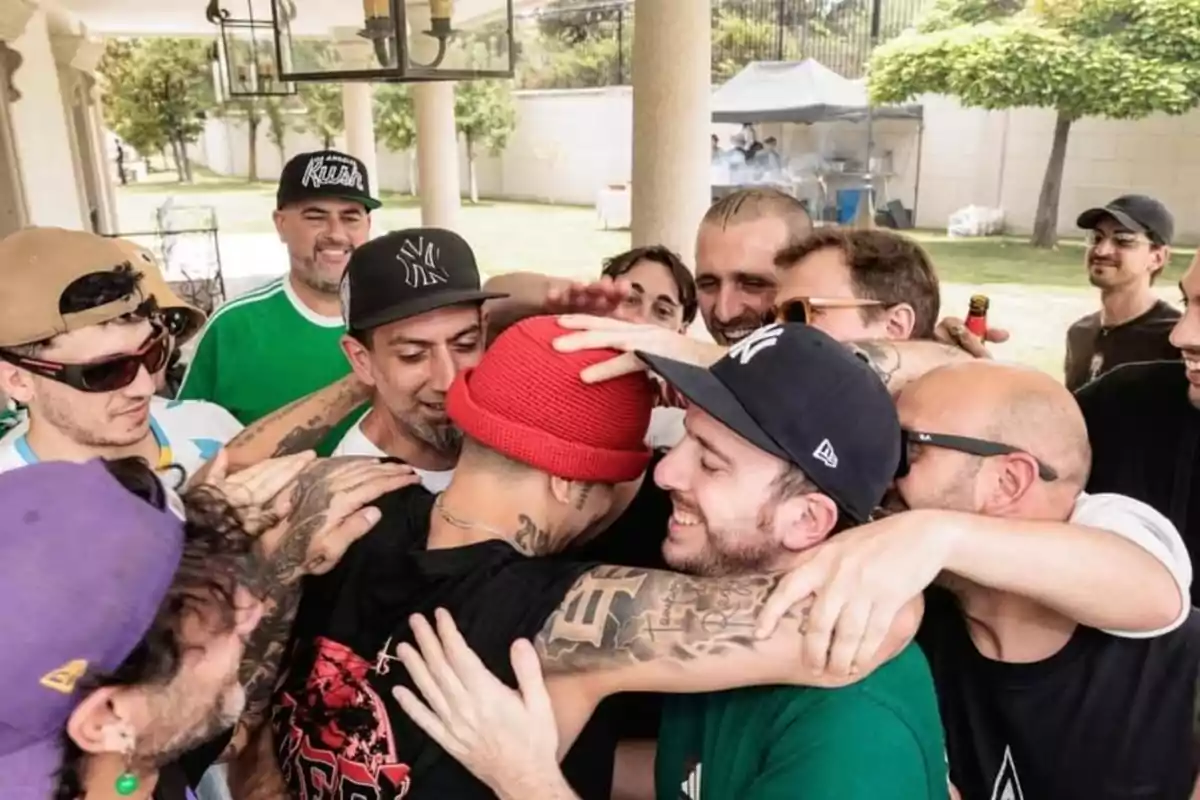 A group of friends smiles and hugs in an outdoor setting during a gathering or celebration. A group of friends smiles and hugs in an outdoor setting during a gathering or celebration.
