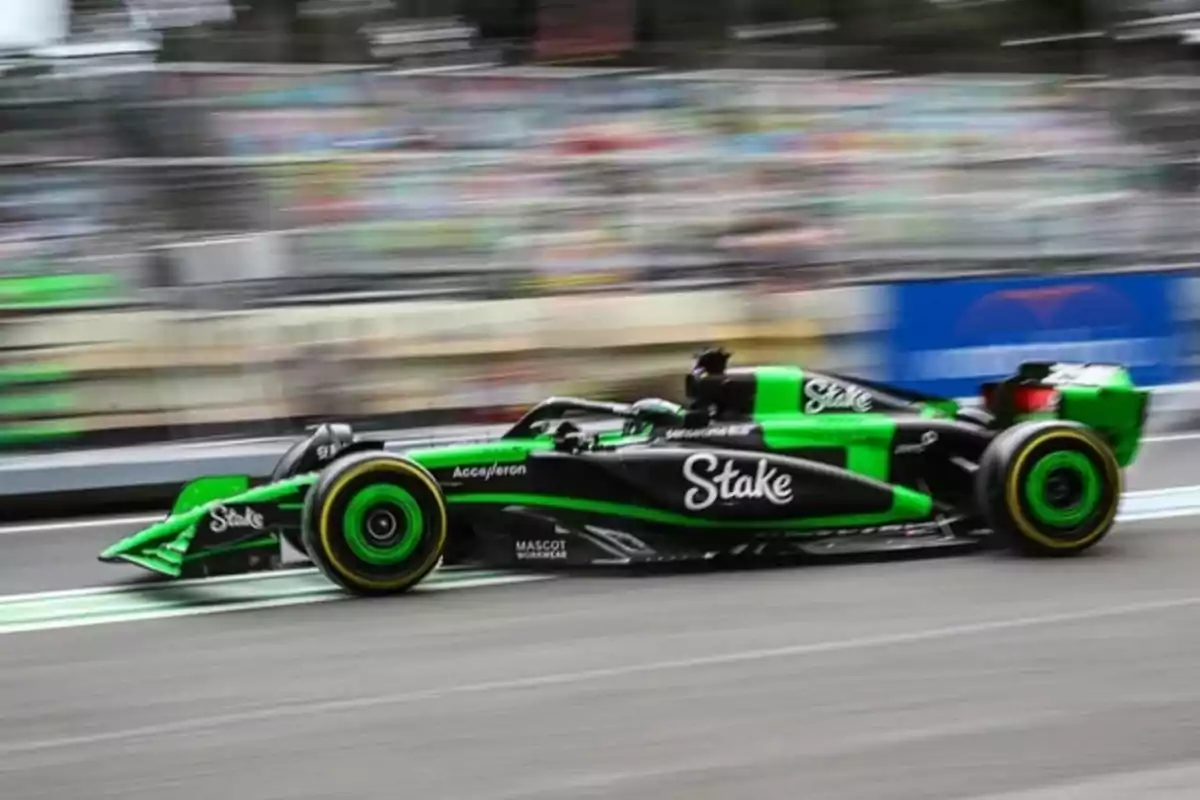 Un auto de Fórmula 1 verde y negro circula a gran velocidad en una pista de carreras con el fondo desenfocado por el movimiento Un auto de Fórmula 1 verde y negro circula a gran velocidad en una pista de carreras con el fondo desenfocado por el movimiento