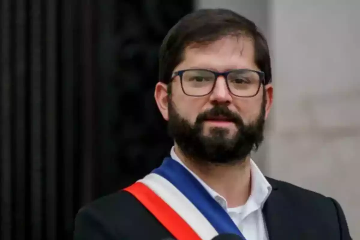 Hombre con barba y gafas usando una banda presidencial tricolor y traje oscuro Hombre con barba y gafas usando una banda presidencial tricolor y traje oscuro