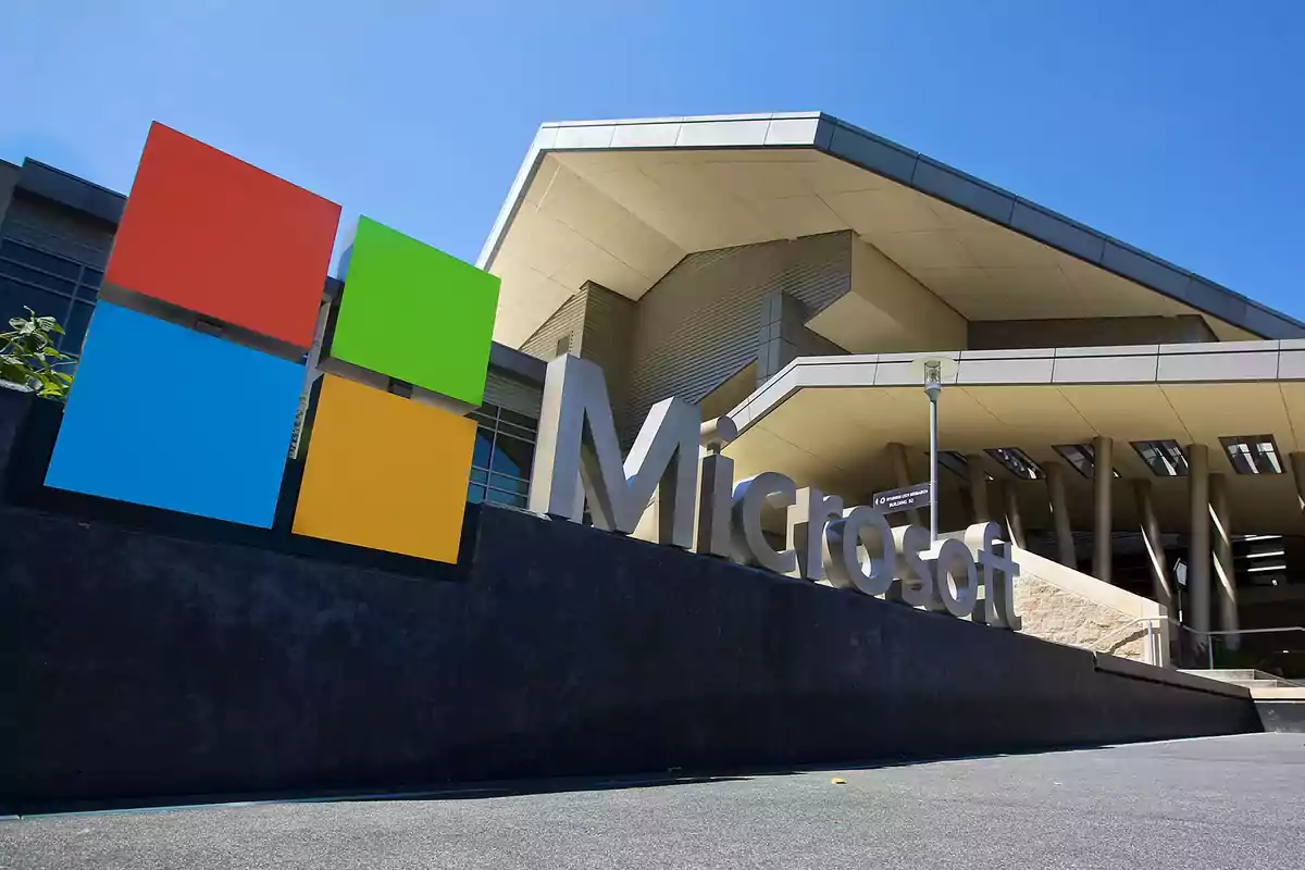Edificio moderno con el logo de Microsoft en primer plano bajo un cielo despejado