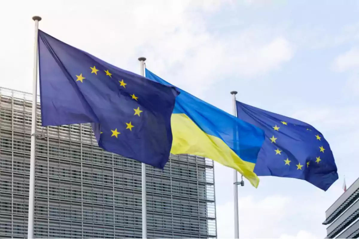 European Union and Ukrainian flags waving in front of a modern building