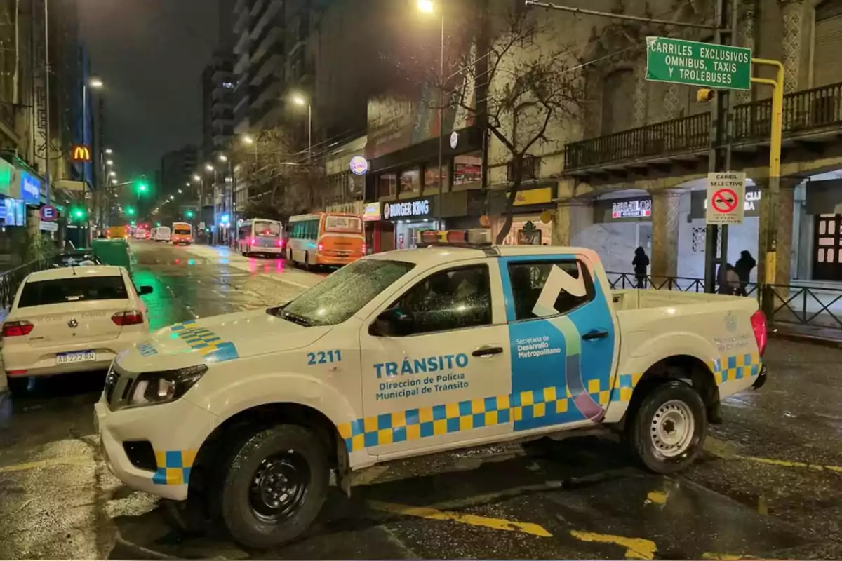 Municipal transit van parked on an urban street at night with city lights and several vehicles in the background Municipal transit van parked on an urban street at night with city lights and several vehicles in the background