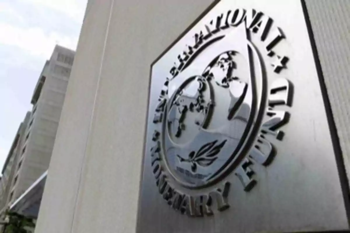 Placa metálica con el logotipo del Fondo Monetario Internacional en la fachada de un edificio