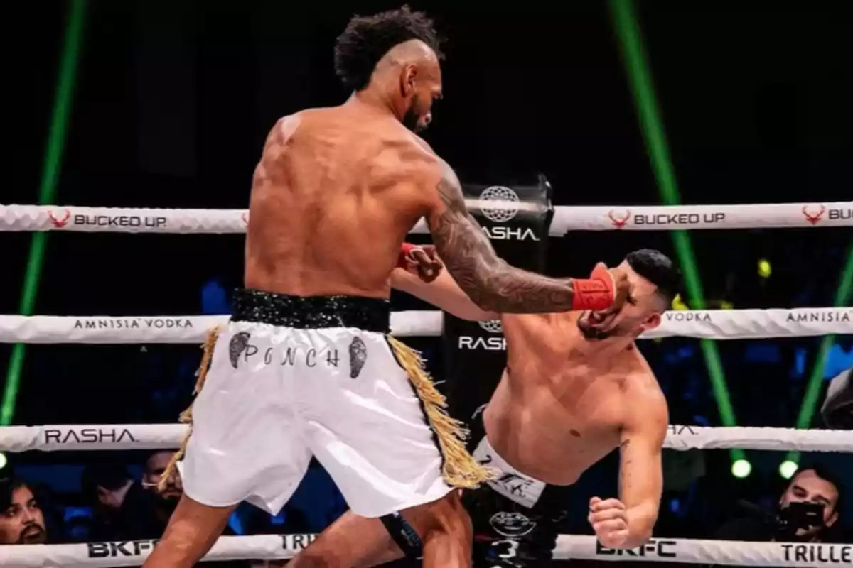 A boxer lands a strong punch to his opponent’s face during a fight in the ring.