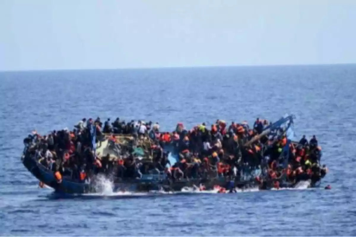 Barco sobrecargado de personas navegando en el mar Barco sobrecargado de personas navegando en el mar