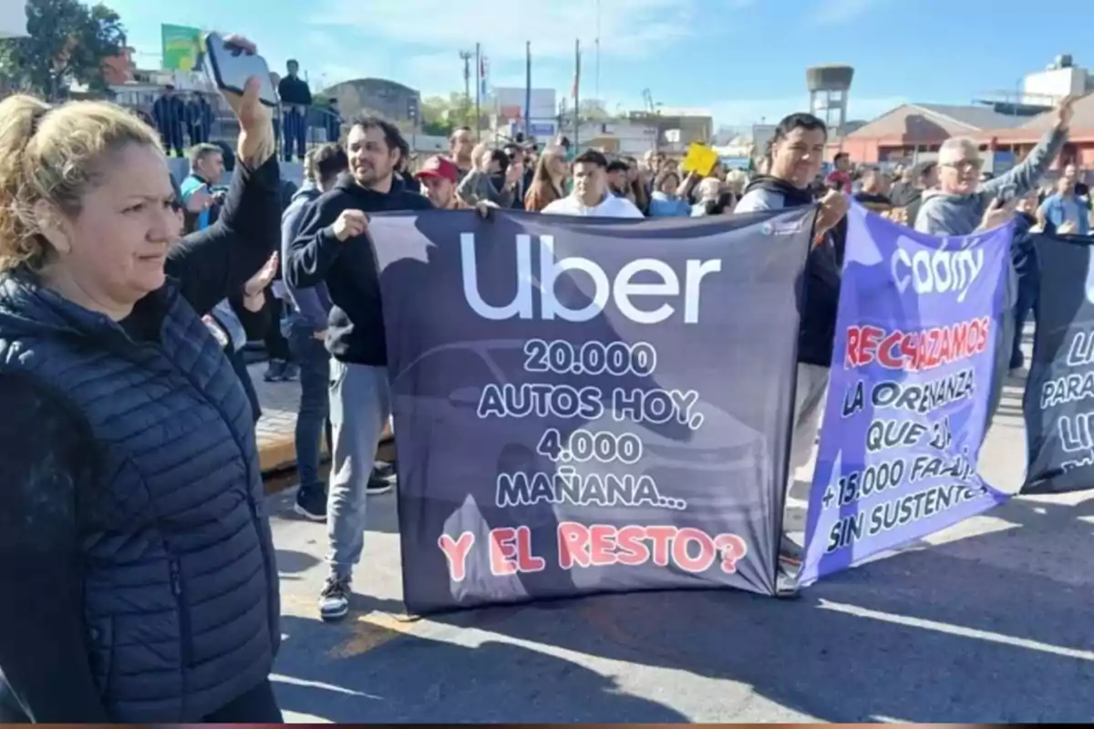 Manifestación de conductores con pancartas de Uber protestando en la calle durante el día