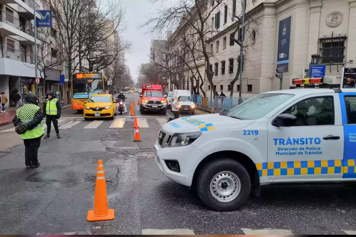 Traffic control on an urban street with police officers, orange cones, official vehicles, a taxi, a bus, and buildings around. Traffic control on an urban street with police officers, orange cones, official vehicles, a taxi, a bus, and buildings around.