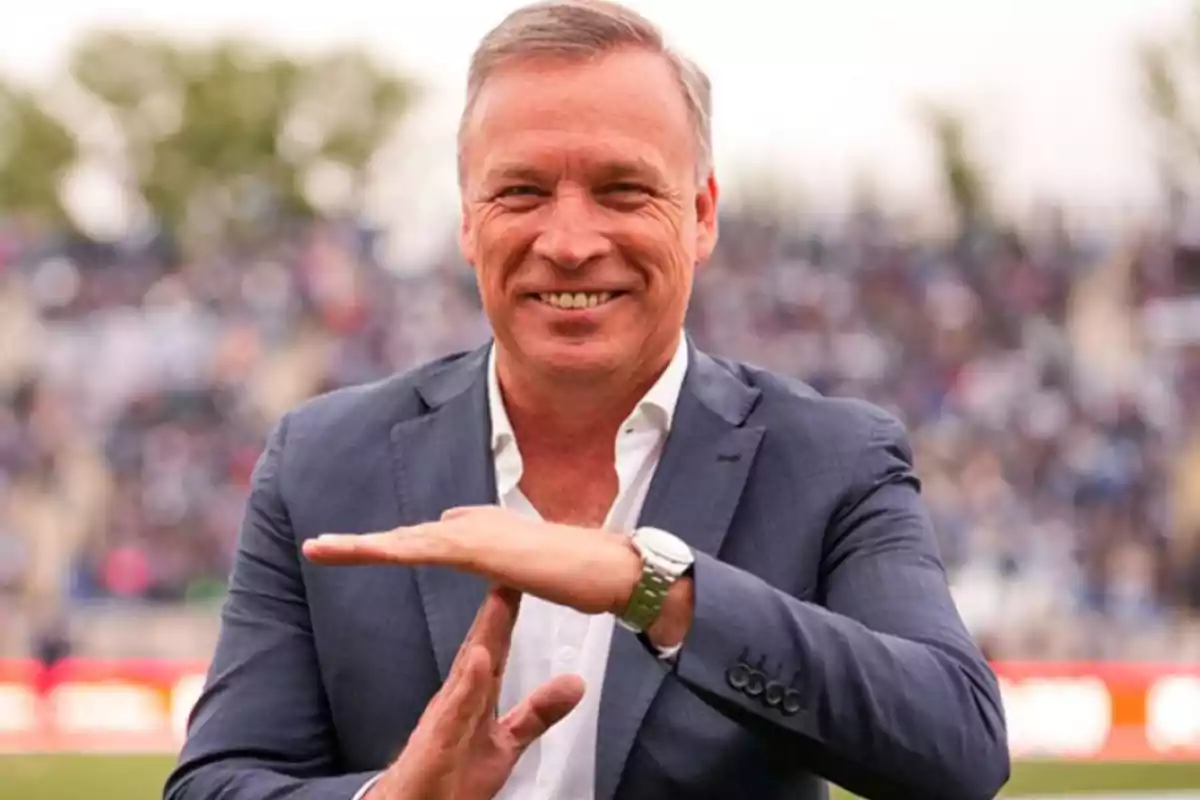 Hombre de traje sonriente haciendo la señal de tiempo fuera con las manos en un estadio al aire libre Hombre de traje sonriente haciendo la señal de tiempo fuera con las manos en un estadio al aire libre