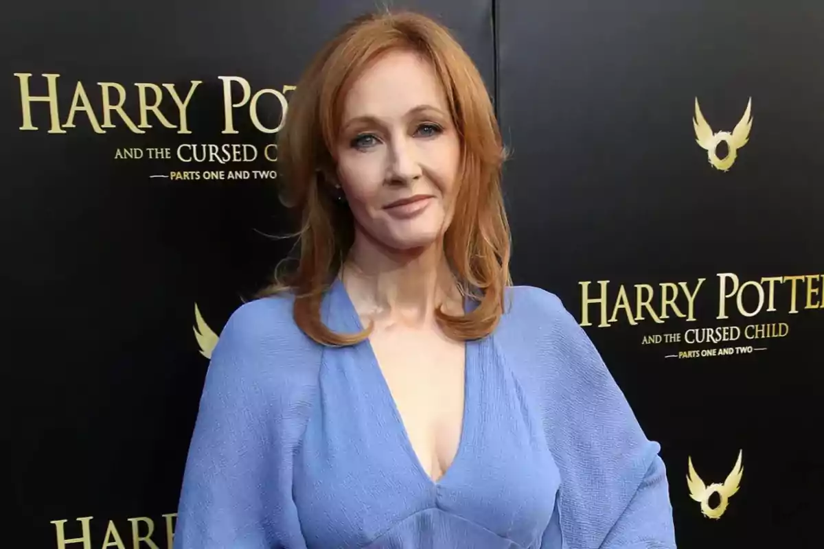 Mujer de cabello pelirrojo con vestido azul claro posando frente a un fondo promocional de Harry Potter and the Cursed Child Mujer de cabello pelirrojo con vestido azul claro posando frente a un fondo promocional de Harry Potter and the Cursed Child