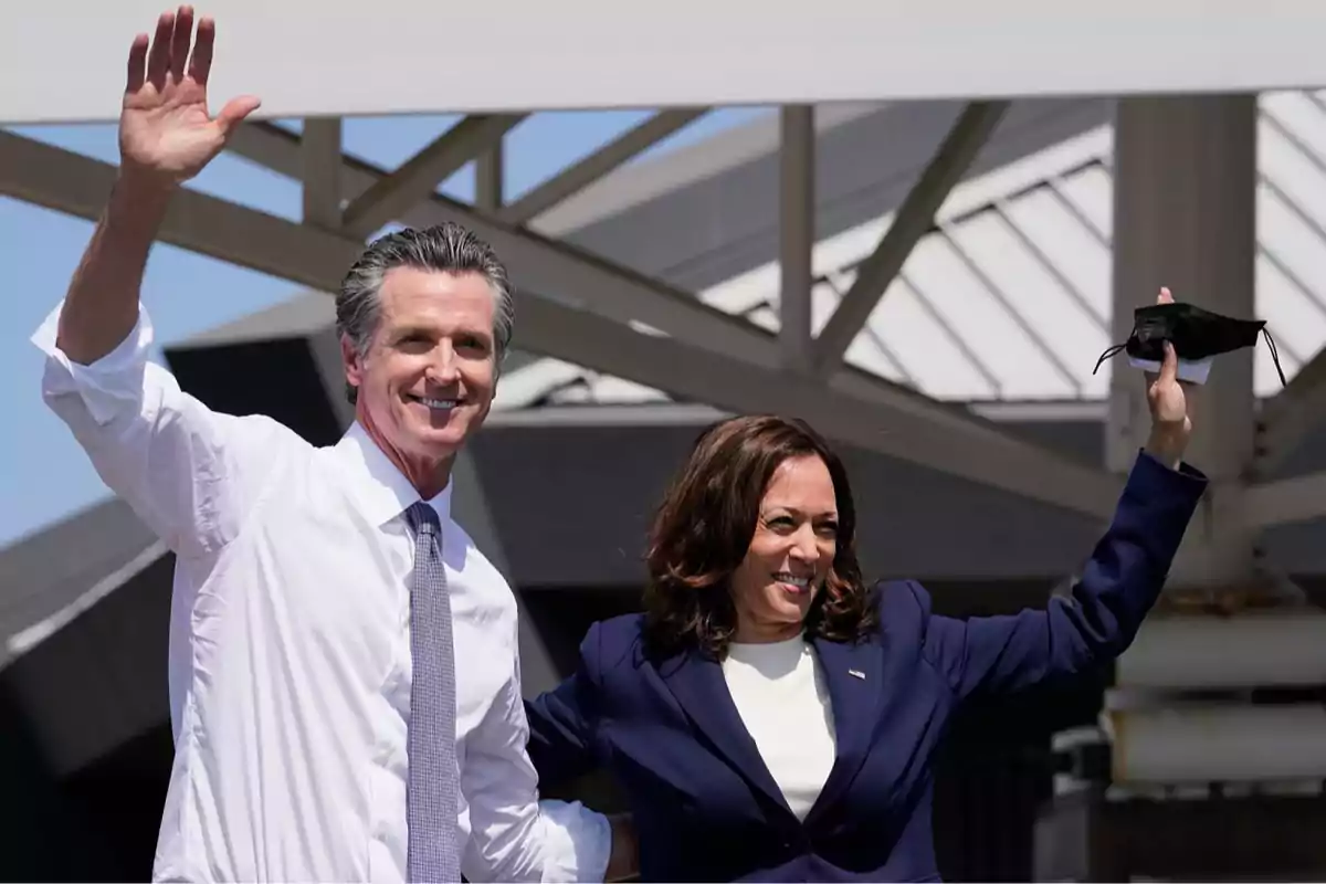 Two people smile and wave by raising their hands at an outdoor event. Two people smile and wave by raising their hands at an outdoor event.