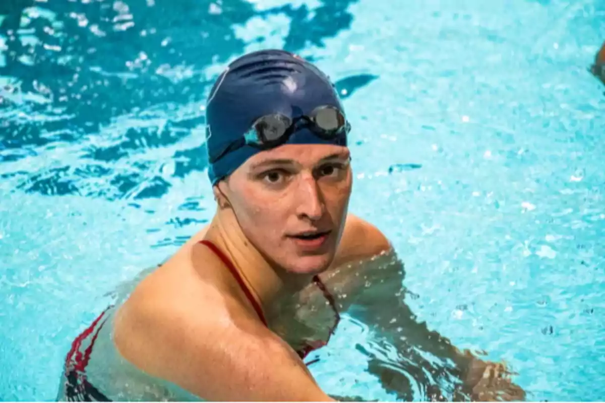 Person wearing a swim cap and goggles in a pool looking at the camera Person wearing a swim cap and goggles in a pool looking at the camera