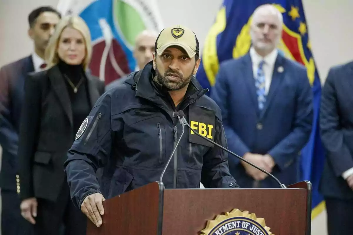 Agente del FBI hablando en una conferencia de prensa con varias personas de traje al fondo