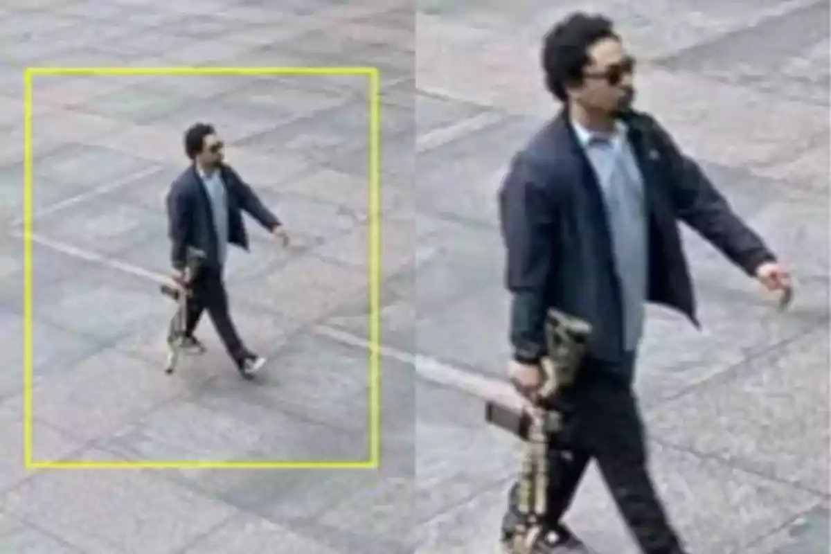 Hombre caminando en la calle sosteniendo lo que parece ser un arma larga y vistiendo ropa casual con gafas oscuras Hombre caminando en la calle sosteniendo lo que parece ser un arma larga y vistiendo ropa casual con gafas oscuras
