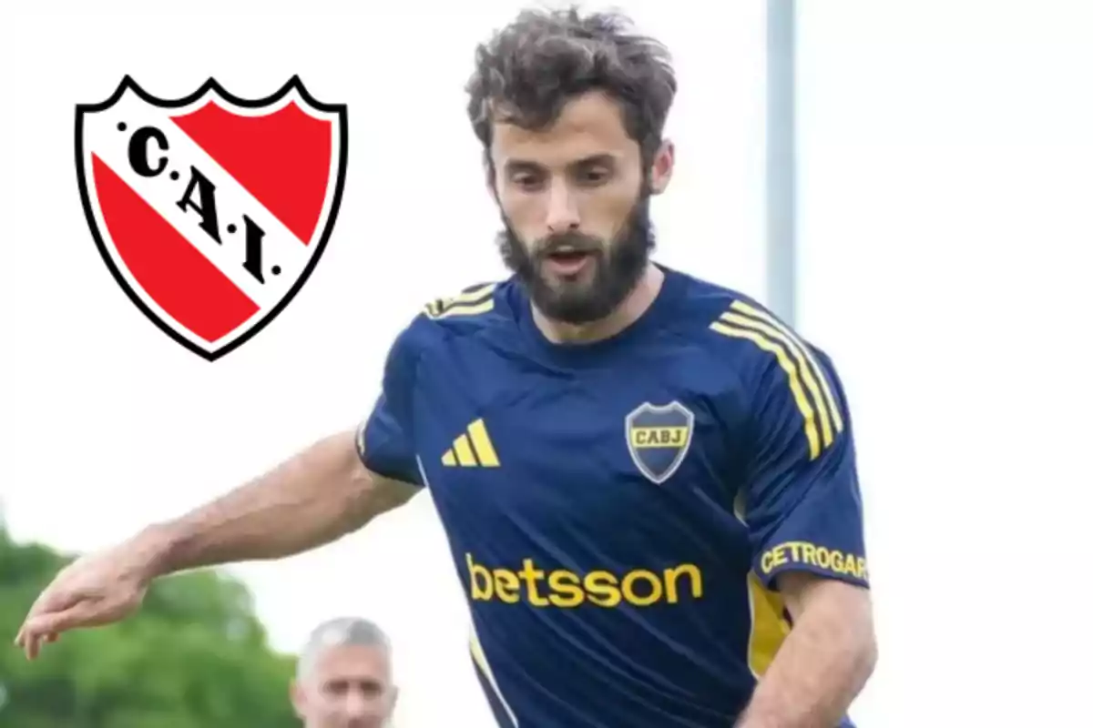 Soccer player wearing a Boca Juniors jersey in action with the Independiente crest in the background