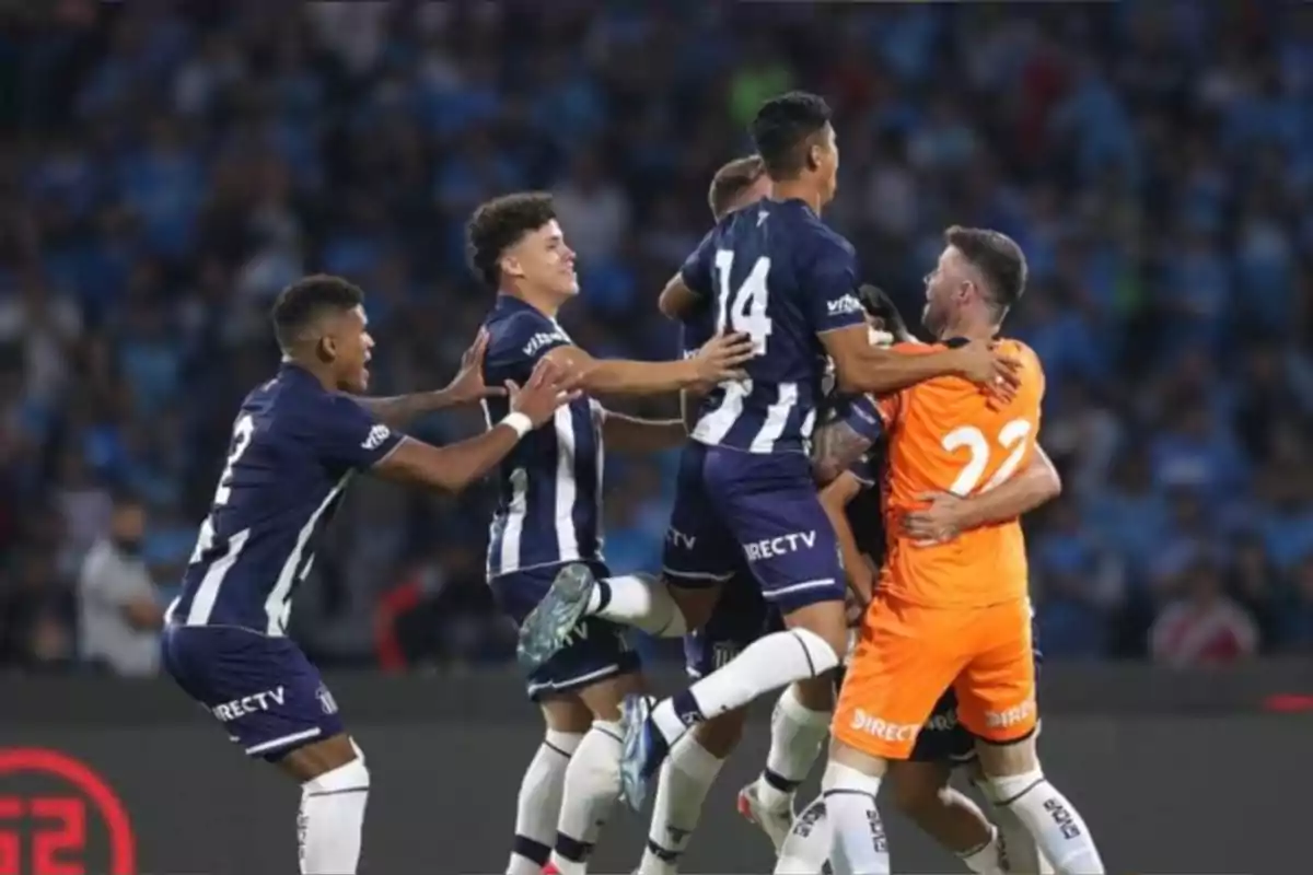 Jugadores de un equipo de fútbol celebran juntos en la cancha durante un partido Jugadores de un equipo de fútbol celebran juntos en la cancha durante un partido