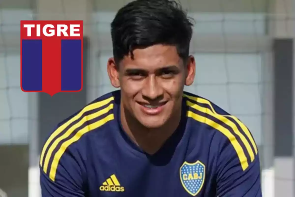 Joven futbolista con camiseta de Boca Juniors sonríe frente a la cámara y a su lado aparece el escudo del club Tigre