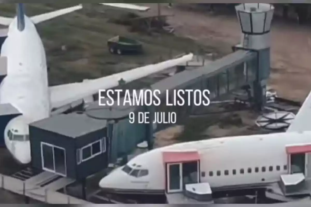Aerial view of two airplanes connected to a terminal with a jet bridge and a control tower, with the text Aerial view of two airplanes connected to a terminal with a jet bridge and a control tower, with the text