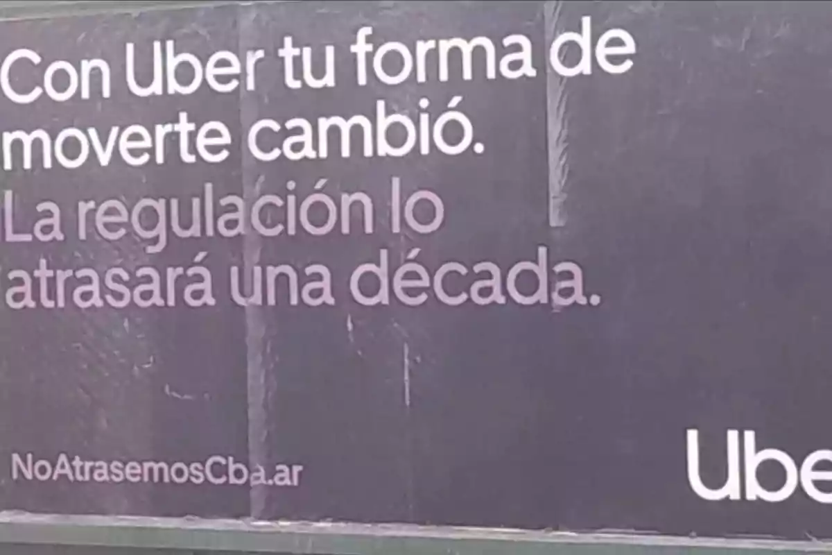 Uber billboard with a dark background and white and purple letters promoting the use of the app and criticizing regulation, claiming it will set progress back a decade Uber billboard with a dark background and white and purple letters promoting the use of the app and criticizing regulation, claiming it will set progress back a decade