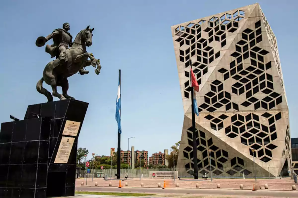 Escultura ecuestre frente a un edificio moderno con diseño geométrico en una ciudad bajo cielo despejado Escultura ecuestre frente a un edificio moderno con diseño geométrico en una ciudad bajo cielo despejado