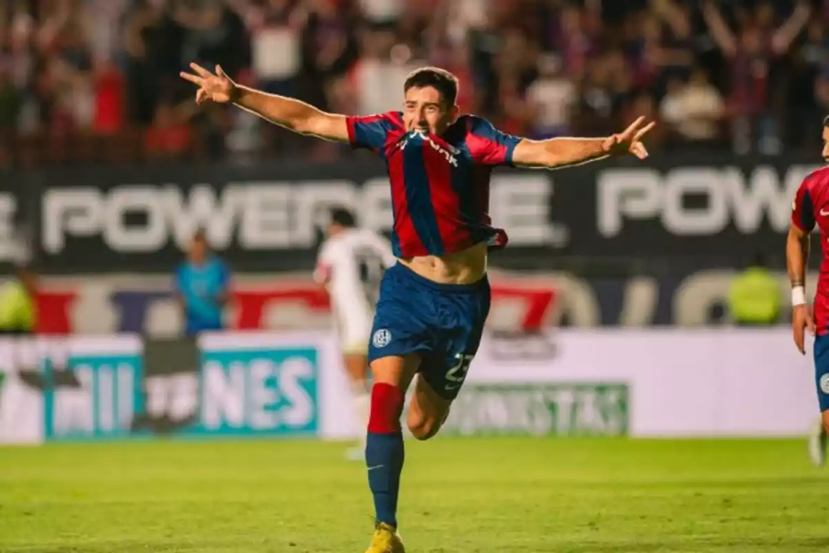 Futbolista celebrando un gol con los brazos extendidos en un estadio lleno de público Futbolista celebrando un gol con los brazos extendidos en un estadio lleno de público