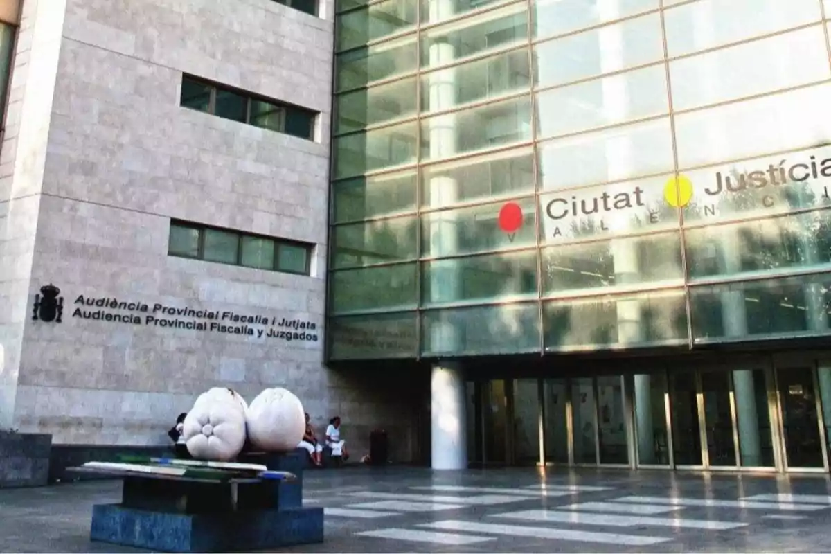 Facade of the City of Justice of Valencia with letters on the wall and a white sculpture at the entrance