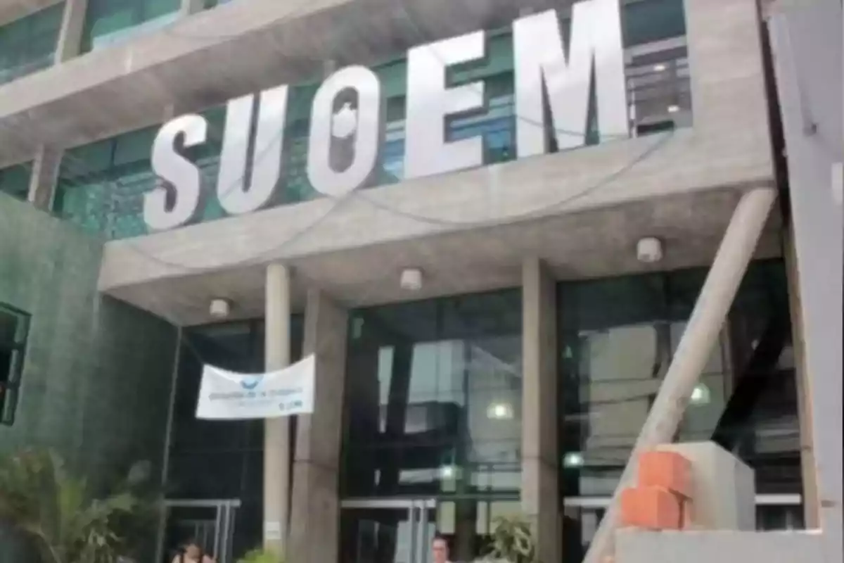 Fachada de un edificio con grandes letras que forman la palabra SUOEM