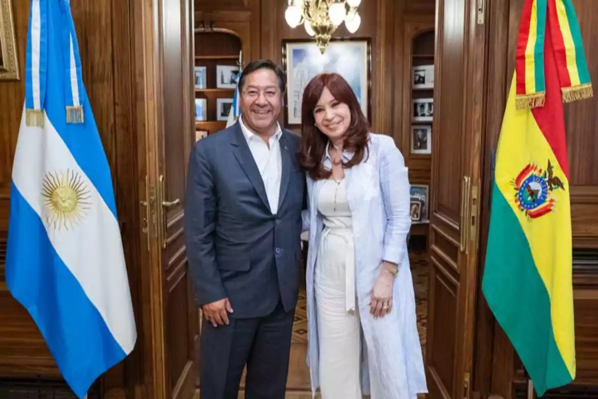 Dos personas posan sonrientes en una oficina elegante con las banderas de Argentina y Bolivia a los lados Dos personas posan sonrientes en una oficina elegante con las banderas de Argentina y Bolivia a los lados