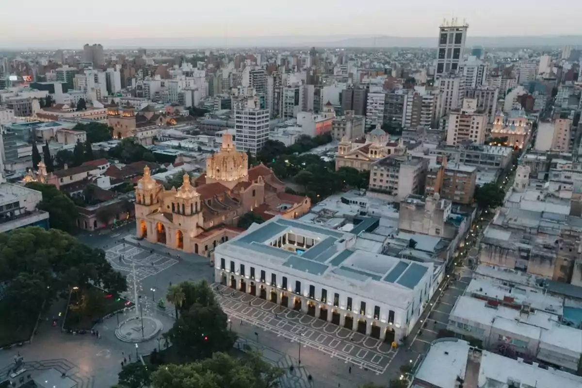 Aerial view of the historic city center with an illuminated cathedral and modern buildings around it