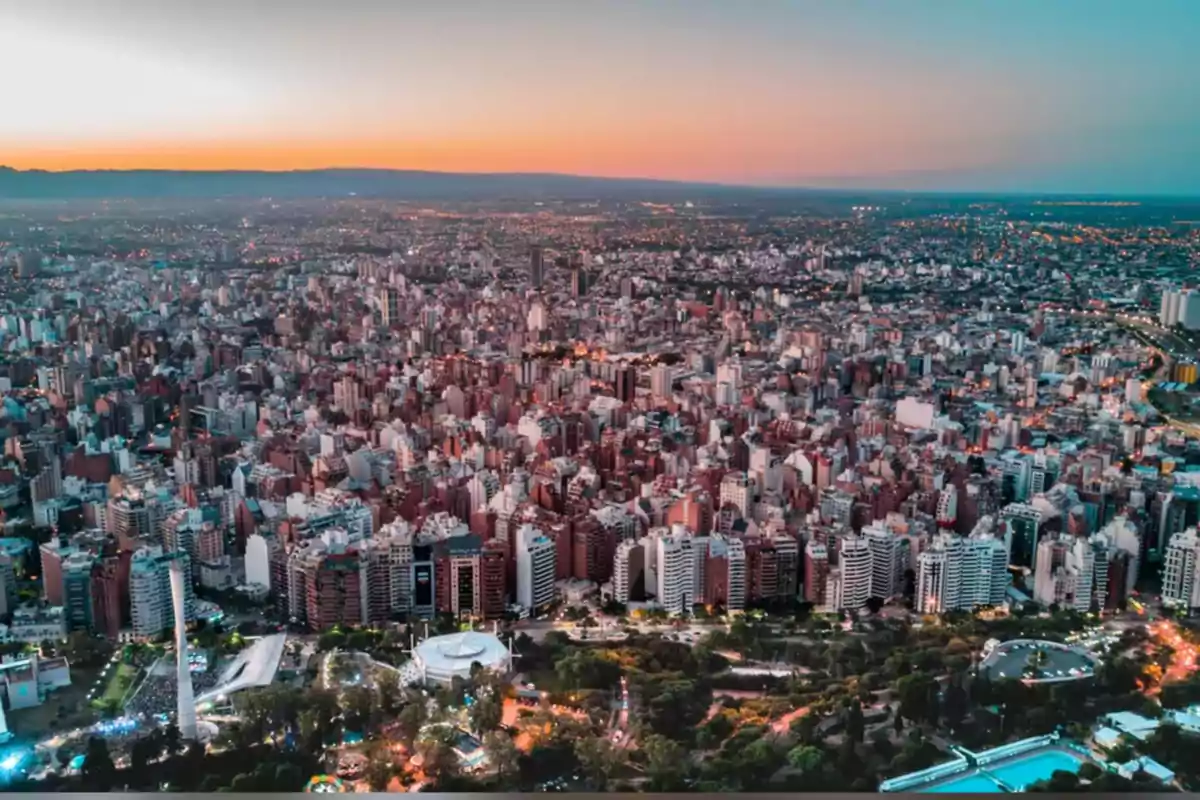 Panoramic view of a city at sunset with numerous buildings and green areas in the foreground Panoramic view of a city at sunset with numerous buildings and green areas in the foreground