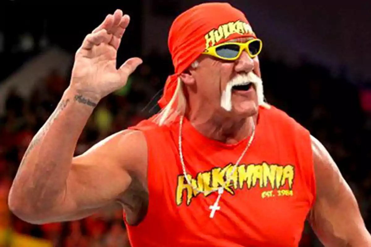 Muscular man with a white mustache, red t-jersey and bandana, yellow sunglasses, and a gesture of listening to the audience Muscular man with a white mustache, red t-jersey and bandana, yellow sunglasses, and a gesture of listening to the audience