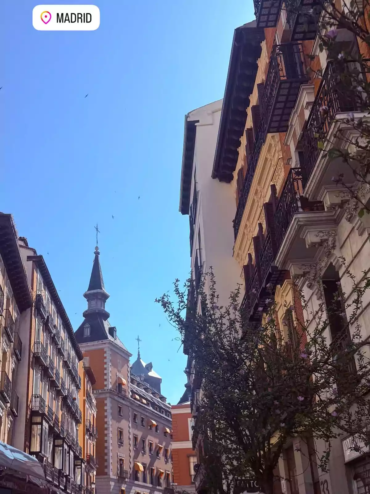 Calle de Madrid con edificios históricos, balcones y un cielo despejado Calle de Madrid con edificios históricos, balcones y un cielo despejado