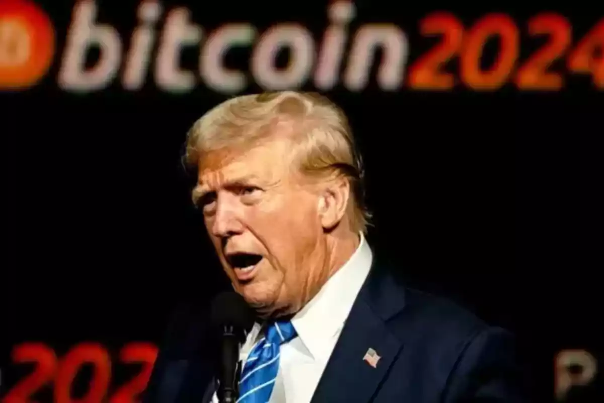 Hombre de cabello rubio con traje azul y corbata hablando frente a un micrófono con la palabra bitcoin 2024 desenfocada al fondo Hombre de cabello rubio con traje azul y corbata hablando frente a un micrófono con la palabra bitcoin 2024 desenfocada al fondo