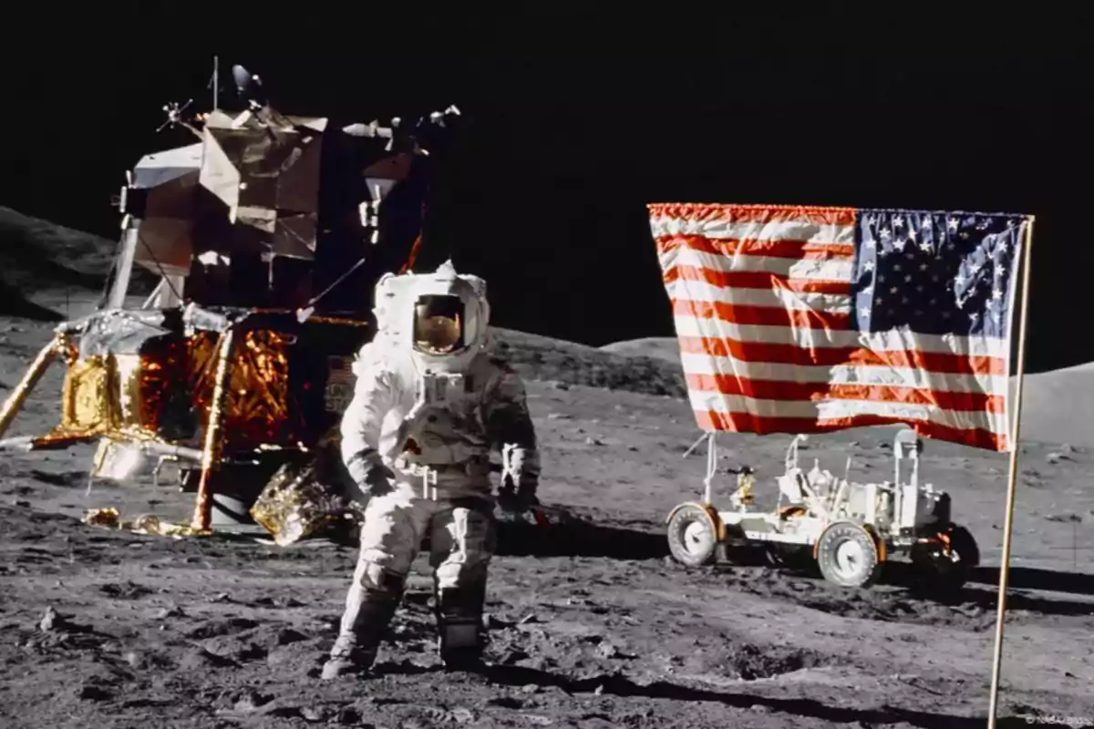Astronauta en la superficie lunar junto a un módulo lunar, una bandera de Estados Unidos y un vehículo lunar Astronauta en la superficie lunar junto a un módulo lunar, una bandera de Estados Unidos y un vehículo lunar