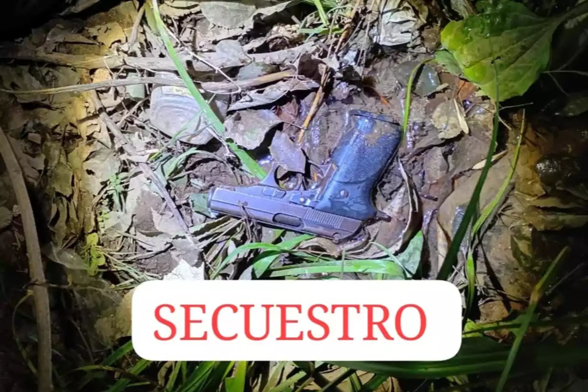 Pistola negra tirada en el suelo entre hojas y pasto con la palabra secuestro en letras rojas al frente Pistola negra tirada en el suelo entre hojas y pasto con la palabra secuestro en letras rojas al frente