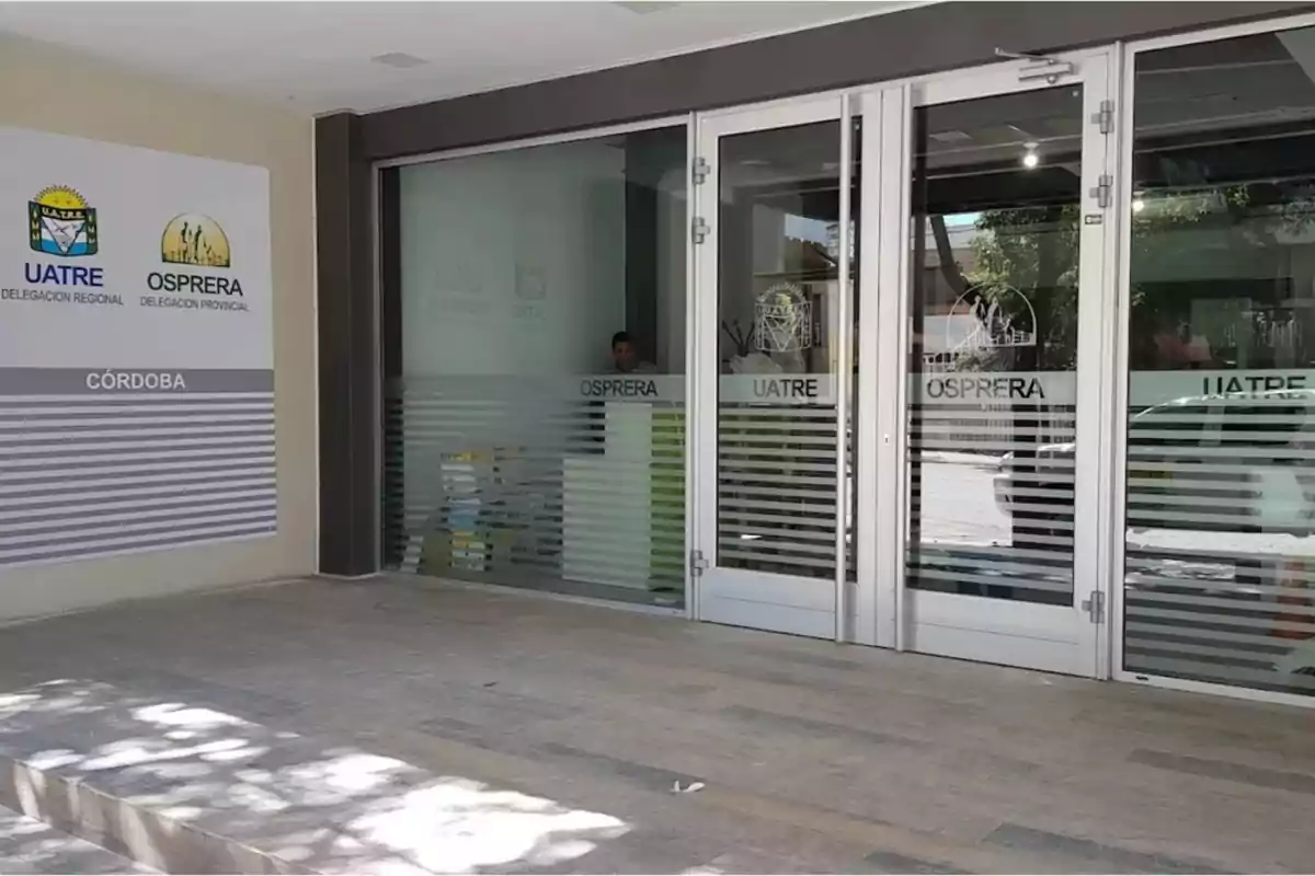 Entrada de un edificio con puertas de vidrio y carteles de UATRE y OSPRERA en la ciudad de Córdoba Entrada de un edificio con puertas de vidrio y carteles de UATRE y OSPRERA en la ciudad de Córdoba