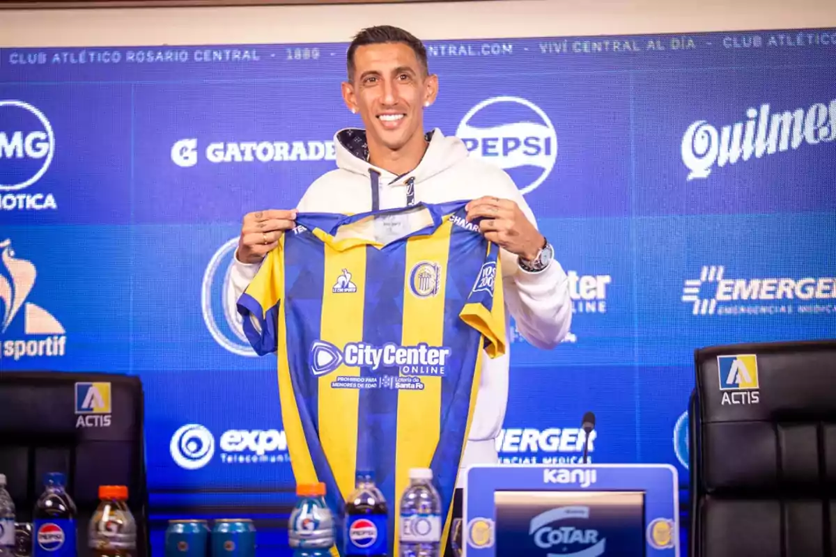 Smiling player holds the Rosario Central jersey during a press conference Smiling player holds the Rosario Central jersey during a press conference