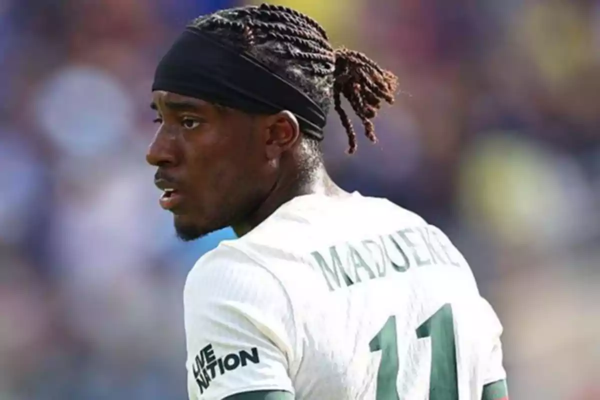 Soccer player with a braid and a black headband wearing a white jersey with the name Madueke and the number 11 Soccer player with a braid and a black headband wearing a white jersey with the name Madueke and the number 11