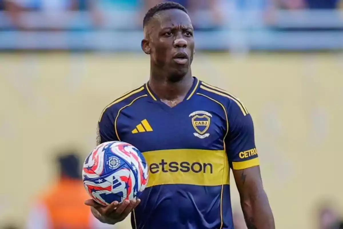 Soccer player in a blue and yellow Boca Juniors uniform holding a ball during a match