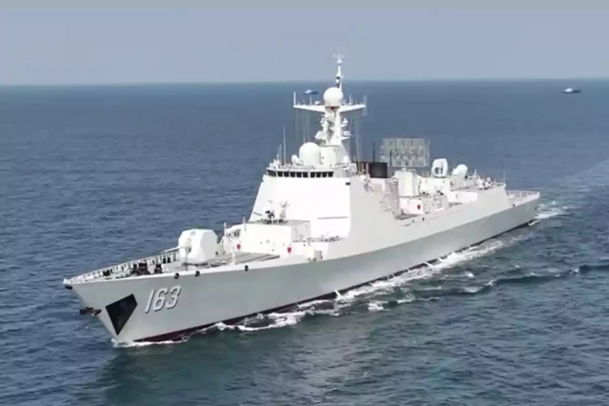 Buque de guerra gris navegando en el mar con el número 163 visible en la proa