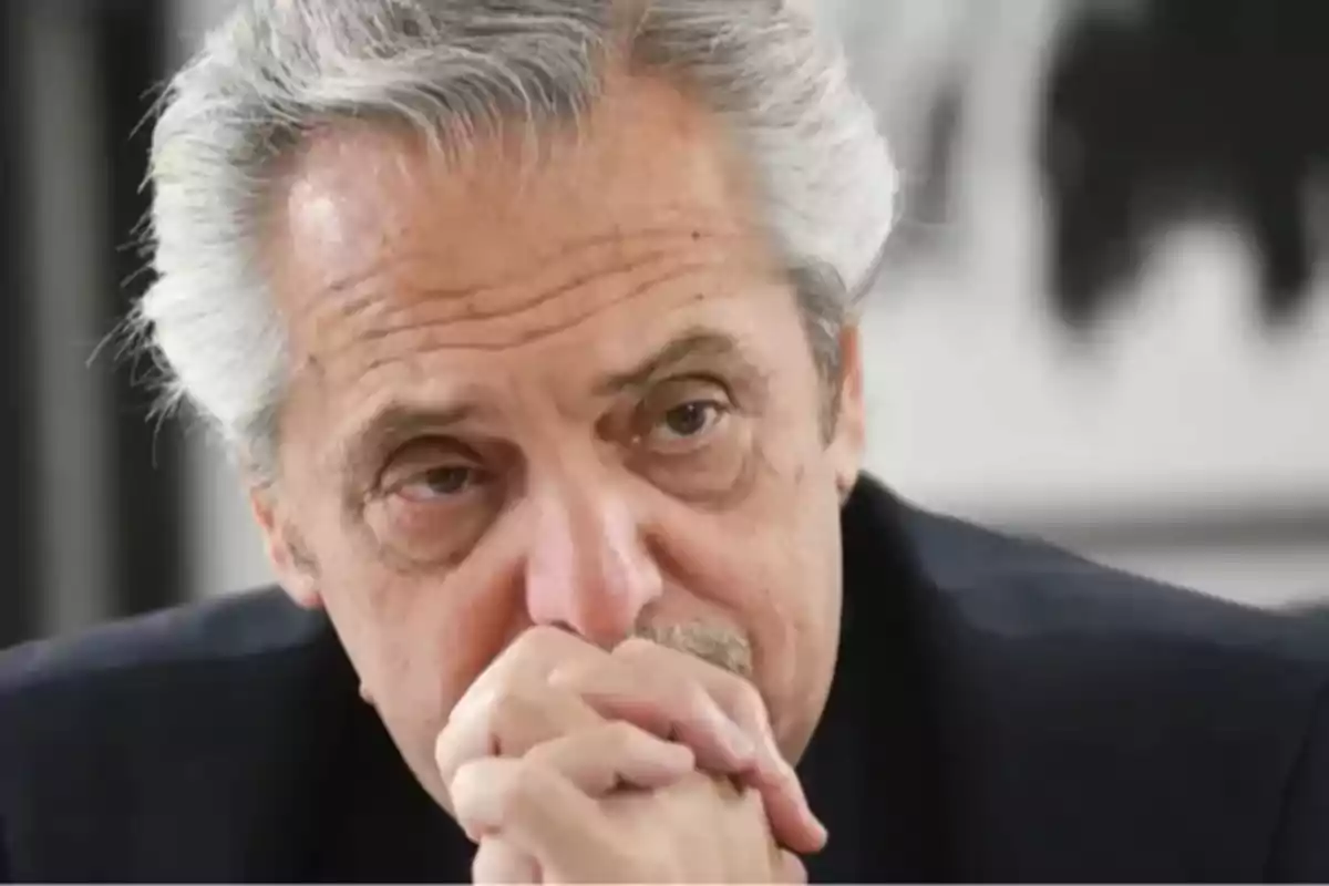 Gray-haired man with a serious expression and hands clasped in front of his face Gray-haired man with a serious expression and hands clasped in front of his face